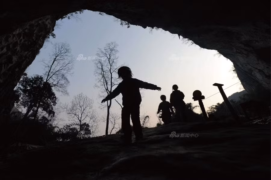 Những đứa trẻ Bố Y vui chơi trước cửa động và cũng là ngôi nhà, ngôi làng của chúng