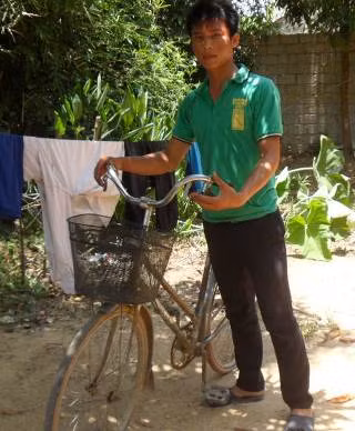 Em Ngô Văn Thuận bên chiếc xe đạp cọc cạch đã giúp em tạo nên kỳ tích trong đợt thi đại học vừa qua.