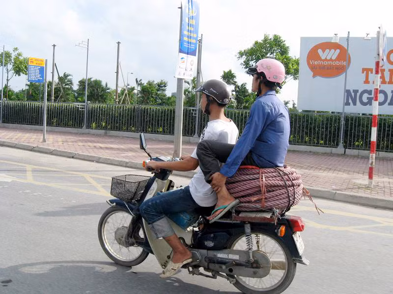 Ngồi vắt vẻo trên xe máy bất chấp nguy hiểm