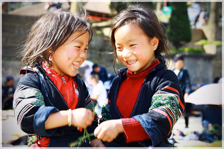 Nụ cười bẽn lẽn của hai bé gái người H'Mong đen ở trung tâm thị trấn Sapa, Lào Cai.