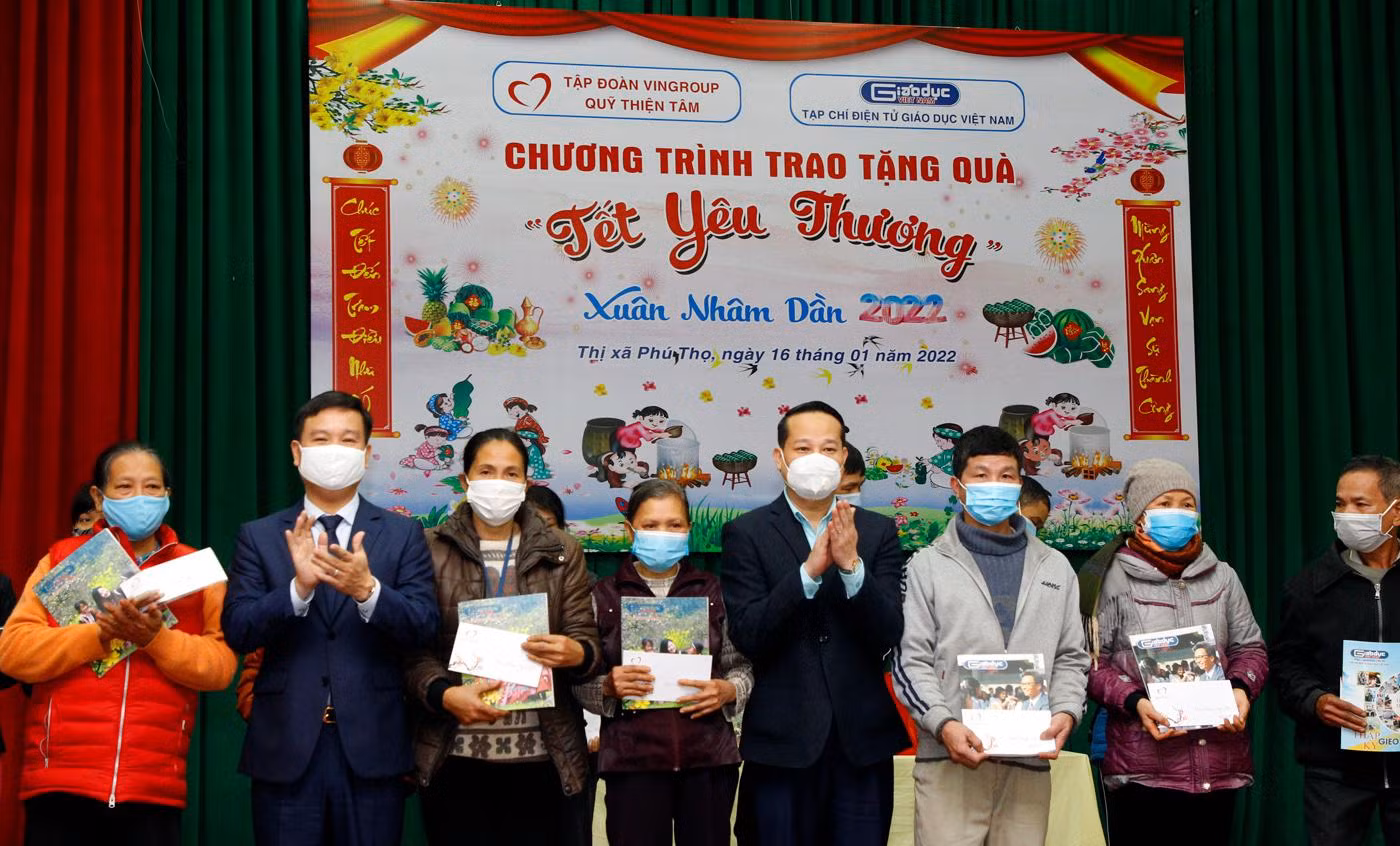 Nhà báo Nguyễn Tiến Bình - Phó Chủ tịch Hiệp hội Các trường đại học, cao đẳng Việt Nam, Tổng biên tập Tạp chí điện tử Giáo dục Việt Nam và ông Nguyễn Công Huân - Phó Chủ tịch Ủy ban nhân dân Thị xã Phú Thọ (tỉnh Phú Thọ) trao quà Tết cho một số hộ nghèo. Ảnh: T.D.