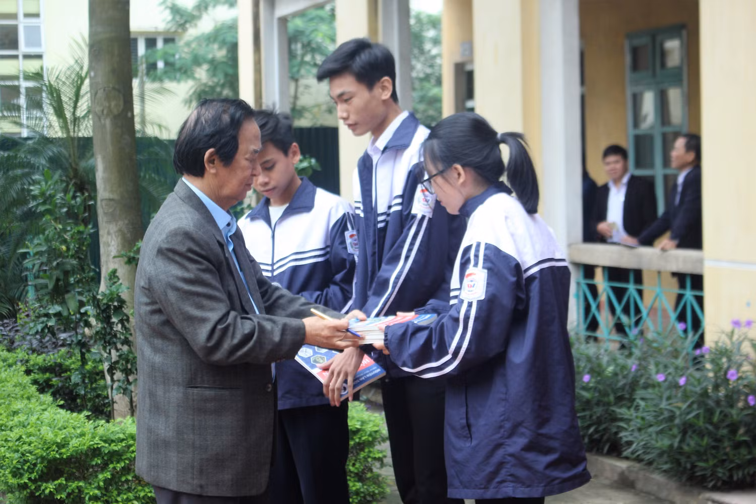 Giáo sư Nguyễn Lân Dũng ký tặng sách cho các bạn học sinh (Ảnh:V.N)