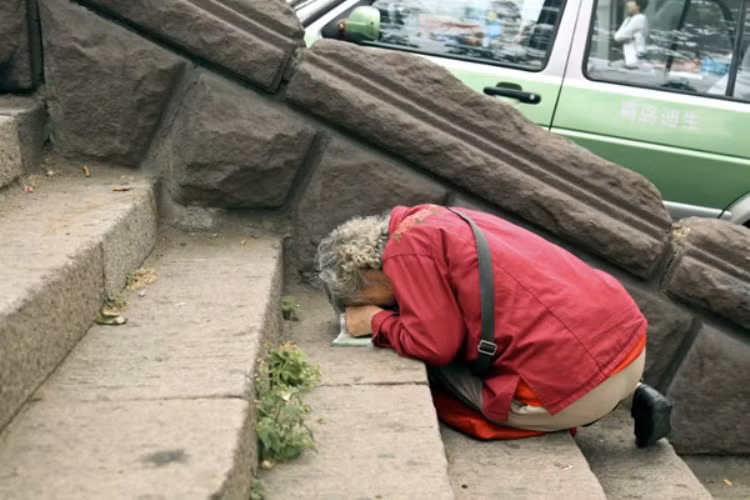 Tại tỉnh Sơn Đông, bà Liu, 72 tuổi đang cầu nguyện cho cháu trai của mình thi tốt. (Ảnh: Kenh14)