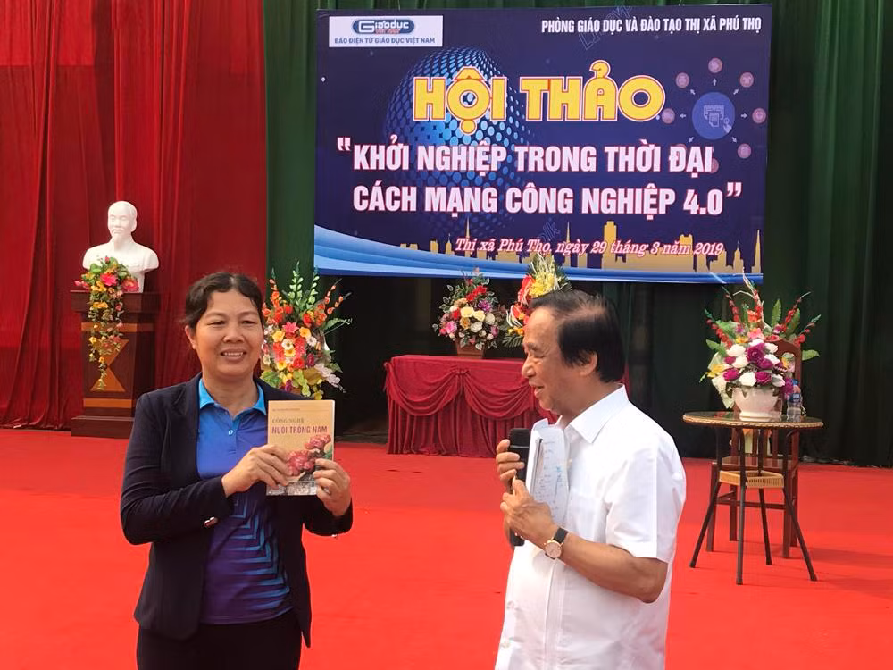 Giáo sư Nguyễn Lân Dũng đã tặng sách dạy cách trồng nấm cho cô giáo Nguyễn Thị Nhàn - Trường Trung học cơ sở Hùng Vương. Ảnh: Tùng Dương.