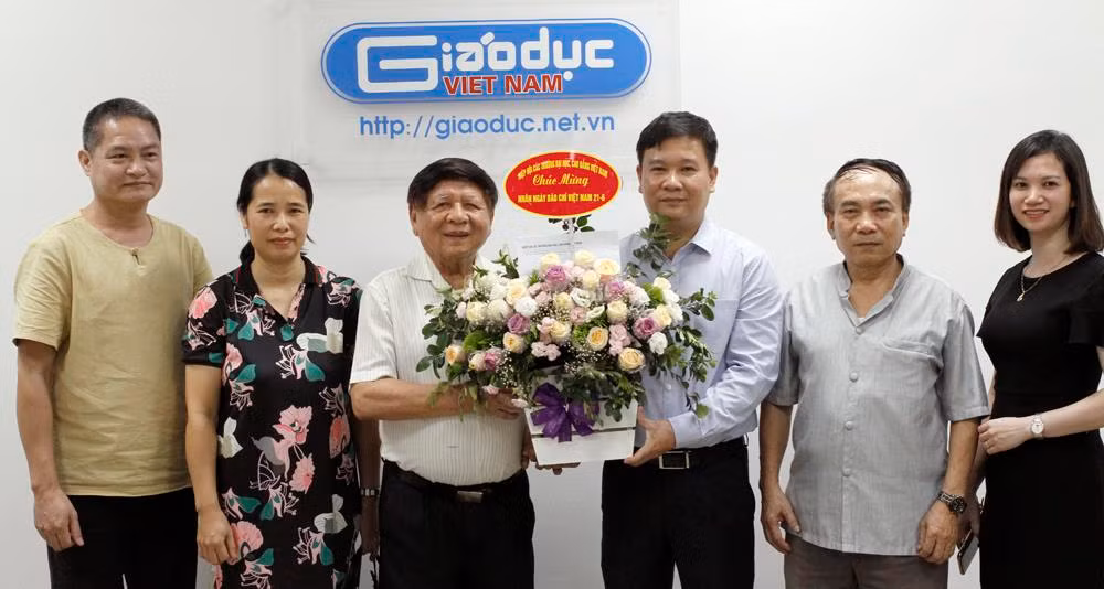 Nhà báo Nguyễn Tiến Bình - Tổng biên tập Báo Điện tử Giáo dục Việt Nam nhận lẵng hoa chúc mừng từ Phó giáo sư, Tiến sĩ Trần Xuân Nhĩ - Phó Chủ tịch Hiệp hội Các trường đại học, cao đẳng Việt Nam. Ảnh: Tùng Dương.
