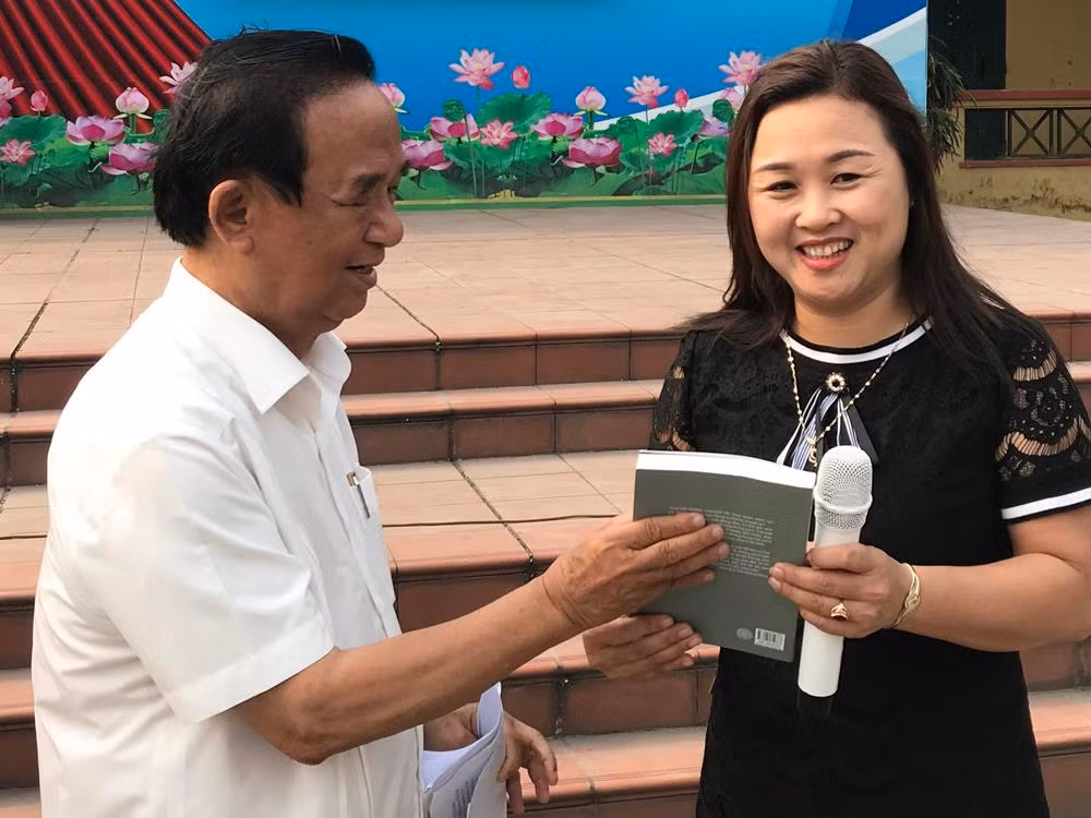Giáo sư, Nhà giáo nhân dân Nguyễn Lân Dũng tặng sách dạy Văn học cho cô giáo Ngô Thanh Lan. Ảnh: Tùng Dương.