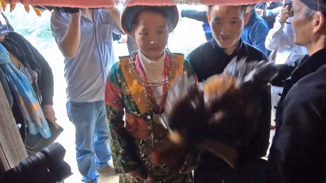 Nhà trai dùng con gà trống làm phép trước khi cô dâu bước vào nhà chồng. Ảnh: Tùng Dương.