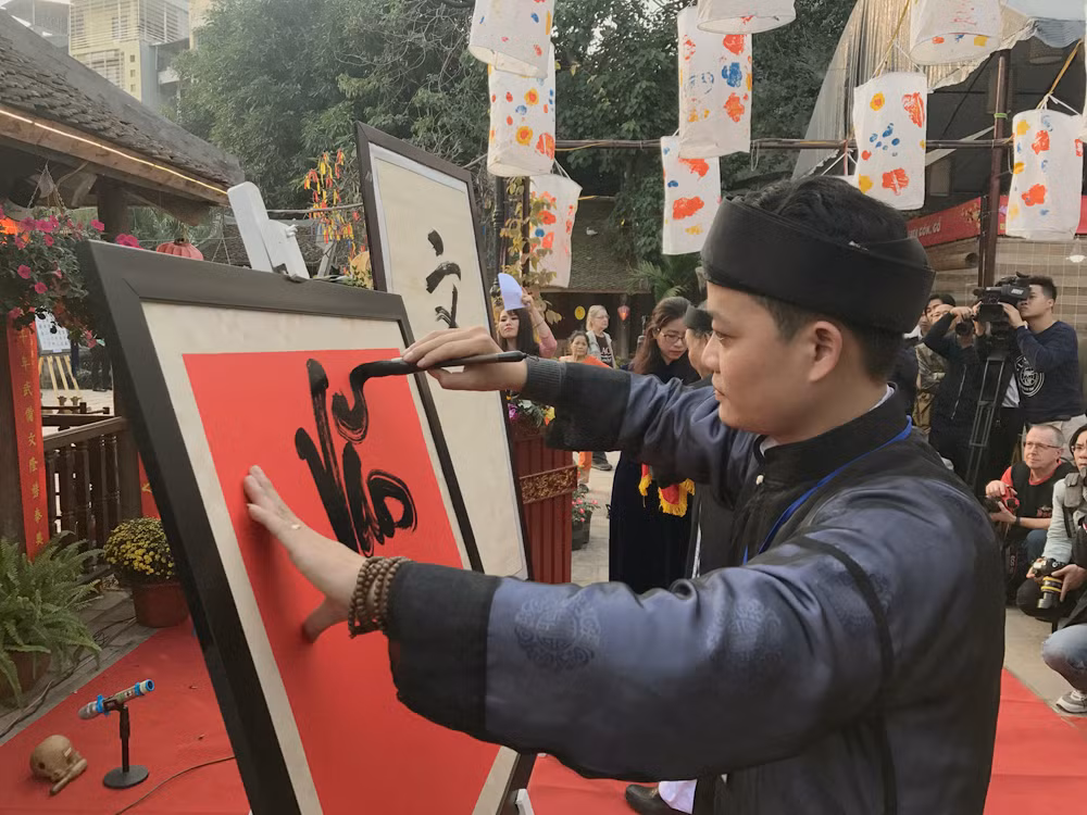 Anh Ngọc Đình đại diện cho lớp trẻ viết chữ Quốc ngữ theo lối thư pháp. Ảnh: Tùng Dương.
