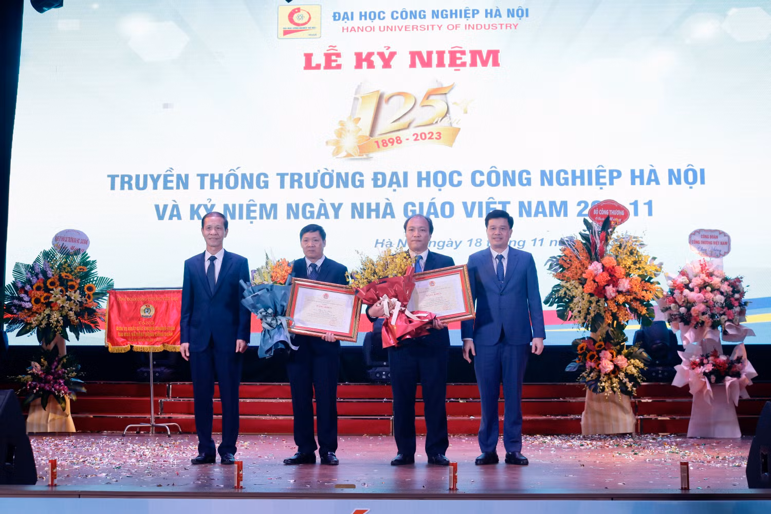 Phó giáo sư Phạm Văn Bổng - Phó Hiệu trưởng và Tiến sĩ Hoàng Mạnh Kha - Trưởng Khoa Điện tử, Trường Đại học Công nghiệp Hà Nội nhận bằng khen của Tổng Liên đoàn lao động Việt Nam