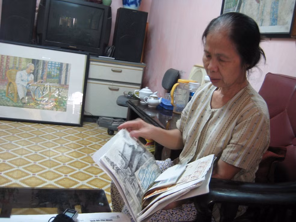 Bà Phạm Thị Uyển đang lần giở lại những con tem mình đã sưu tầm để chuẩn bị cho những bức ghép tranh Bác Hồ.