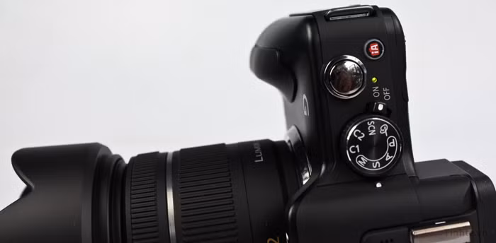 Cận cảnh đỉnh máy, từ trái sang phải ta có loa, nút gạt mở flash, chân đèn, micro trái phải, cụm phím chinh chế độ kiêm công tắc nguồn, nút chụp và nút kích hoạt chế độ thông minh