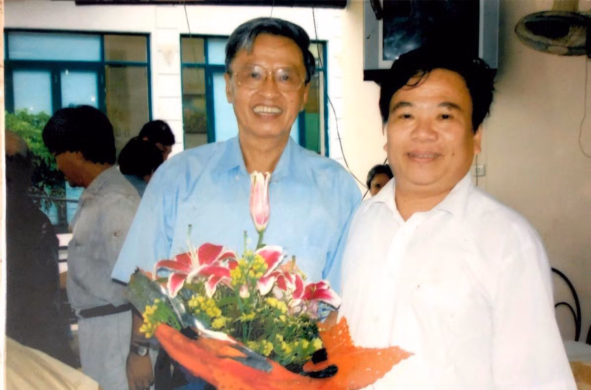 Giáo sư Lê Ngọc Lăng (áo xanh) nhận hoa do Phó Giáo sư Nguyễn Minh Mẫn tặng trong dịp sinh nhật lần thứ 64. Ảnh: Nhân vật cung cấp