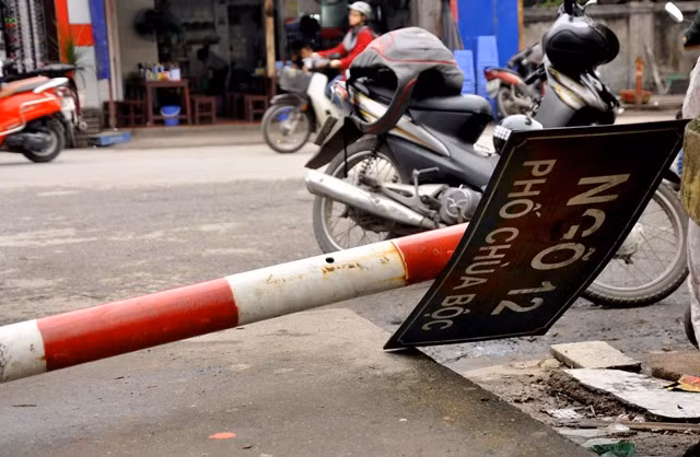 Biển chỉ đường ngõ 12 Chùa Bộc (Đống Đa, Hà Nội) nằm úp dưới đường trong nhiều tháng qua nhưng vẫn chưa được khắc phục ảnh hưởng tới việc đi lại và tìm địa chỉ của người đi đường.