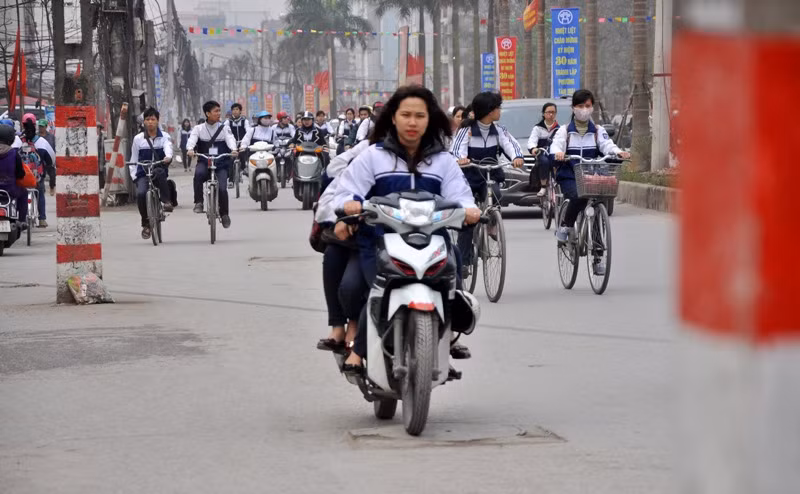 Các học sinh nữ cũng thản nhiên đi xe máy trong tình trạng đầu không đội mũ bảo hiểm, kẹp ba
