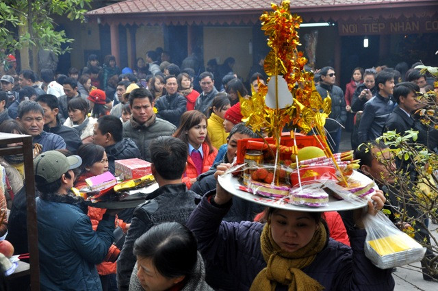 Trong dòng người đông đúc, những mâm lễ được đưa cao trên đầu để đi vào đền Bà Chúa Kho vay nợ.