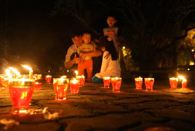 Những em nhỏ chưa một lần gặp người cũng thắp nến cùng cha mẹ để tưởng nhớ công ơn người.