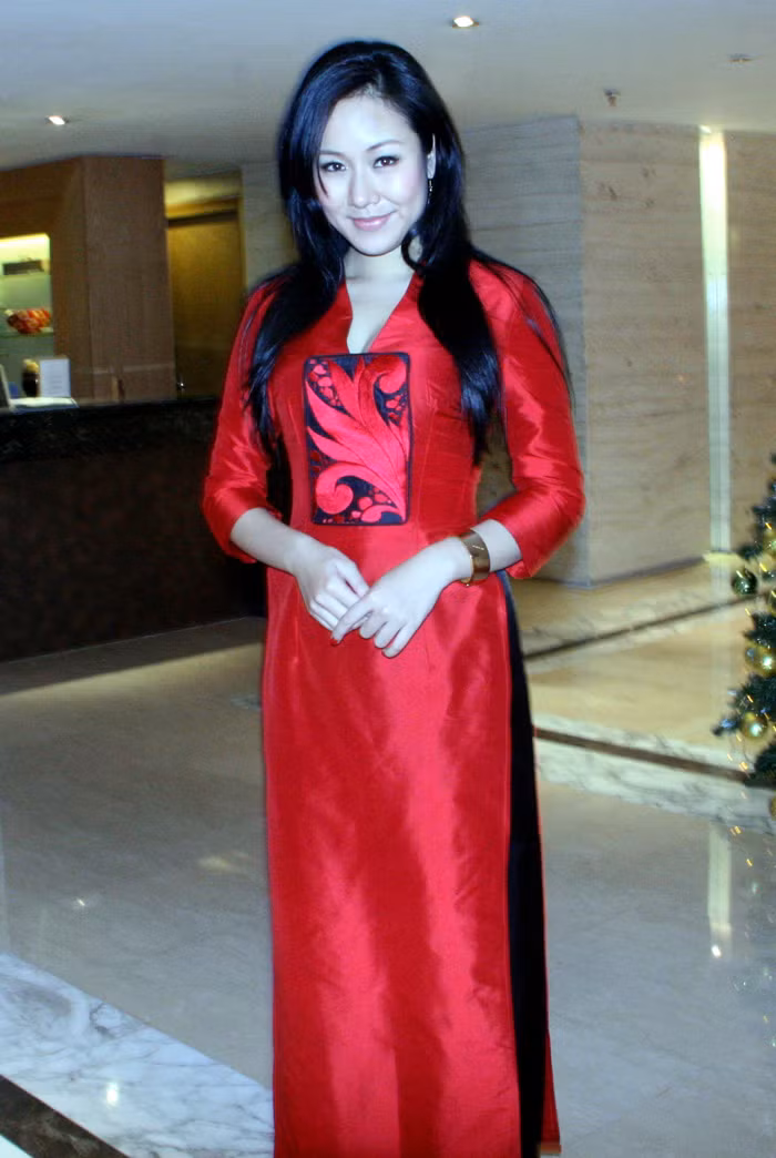 Cô diện một chiếc áo dài màu đỏ.