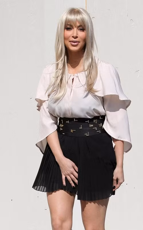 Kim Kardashian liên tục phải dùng tay giữ váy trên suốt đường đi.