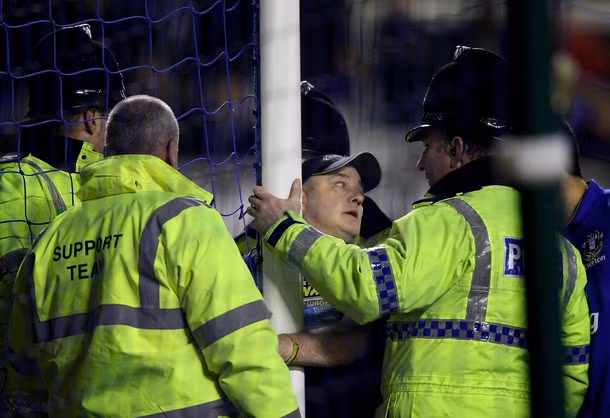 Cảnh sát và lực lượng an ninh sân Goodison Park vất vả giải cứu cổ động viên này. (Xem chùm ảnh ấn tượng vòng đấu: Man đỏ thăng hoa, Man xanh tắt lịm) Cảnh sát và lực lượng an ninh sân Goodison Park vất vả giải cứu cổ động viên này. (Xem chùm ảnh ấn tượng vòng đấu: Man đỏ thăng hoa, Man xanh tắt lịm)