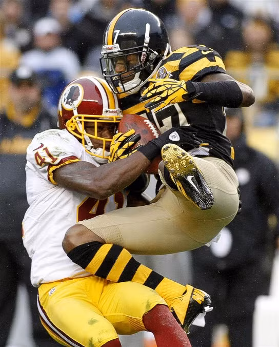 Mike Wallace (áo trắng) của đội Steeler thực hiện cú bắt đường chuyền và va chạm với Madieu Williams của đội Washington. Mike Wallace (áo trắng) của đội Steeler thực hiện cú bắt đường chuyền và va chạm với Madieu Williams của đội Washington.