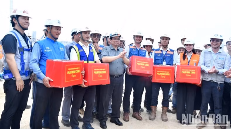 Thủ tướng Phạm Minh Chính tặng quà động viên kỹ sư, công nhân các đơn vị đang thi công Nhà ga hành khách Cảng hàng không quốc tế Long Thành. (Ảnh: Thanh Giang)
