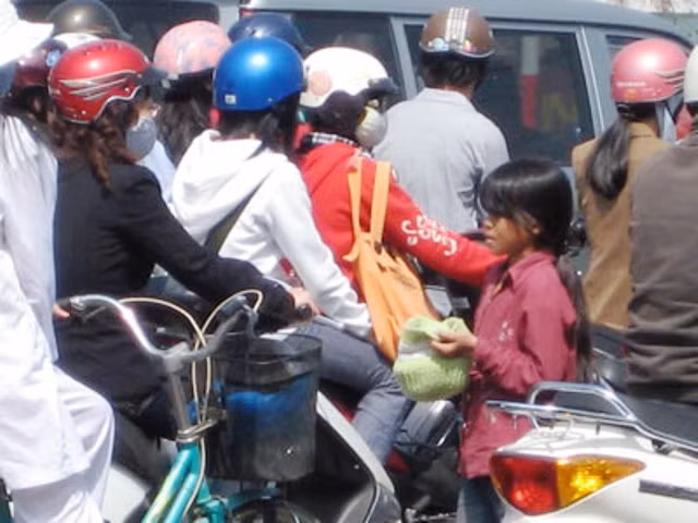 Tại một số giao lộ lớn như: Ngã tư Sở, ngã tư Vọng, Chùa Bộc - Thái Hà… luôn có sự “hiện diện” của những em nhỏ tầm tuổi từ 8 - 12 trong “vai trò” ăn xin với phương thức hoạt động “liên hồi” theo tín hiệu đèn chỉ dẫn giao thông: Đèn đỏ xin tiền, đèn xanh thì tạm nghỉ? (Ảnh: Châu Như Quỳnh)