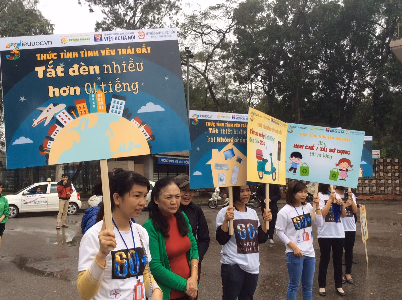 Một loạt tấm bảng với hình vẽ và khẩu hiệu sinh động do chính thầy cô và học sinh tự làm được giơ cao cho cộng đồng cùng biết. Ảnh: Hồng Nhung