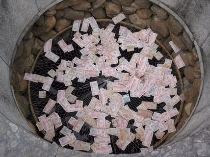 Giếng Mắt Rồng tại đền Kiếp Bạc (Hải Dương) phải được Ban quản lý khu di tích dùng lưới căng ra để...hứng tiền lẻ do khách ném xuống.