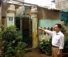 Anh Nguyễn Văn Lan đang đứng cạnh ngôi nhà xây trên diện tích đất nhà ông bị thu hồi.