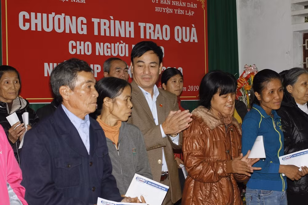 Ông Vũ Đình Thu (đứng giữa), Phó Chủ tịch Ủy ban nhân dân huyện Yên Lập chụp ảnh khi trao quà với các hộ gia đình (ảnh Trinh Phúc).