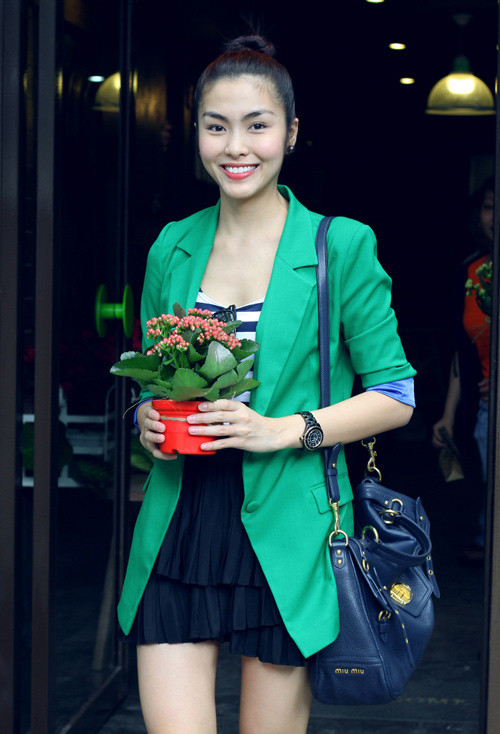 Trẻ trung với váy ngắn xếp li, áo kẻ, blazer xanh và túi đeo vai big size của Miu Miu.