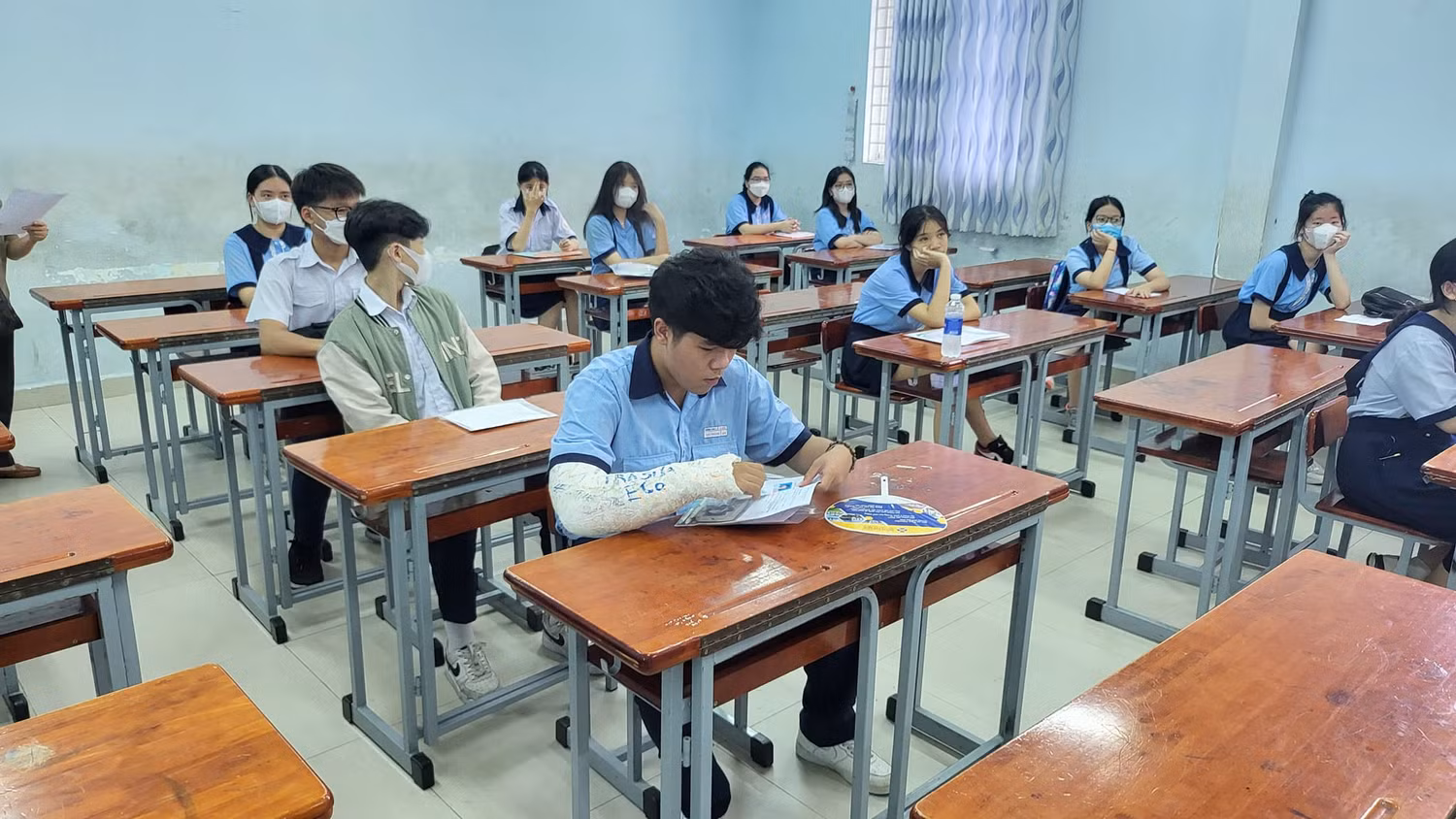Em Nguyễn Vạn Thành bị gãy tay phải nhưng vẫn cố gắng đến làm thủ tục trong ngày đầu tiên (ảnh: P.L)