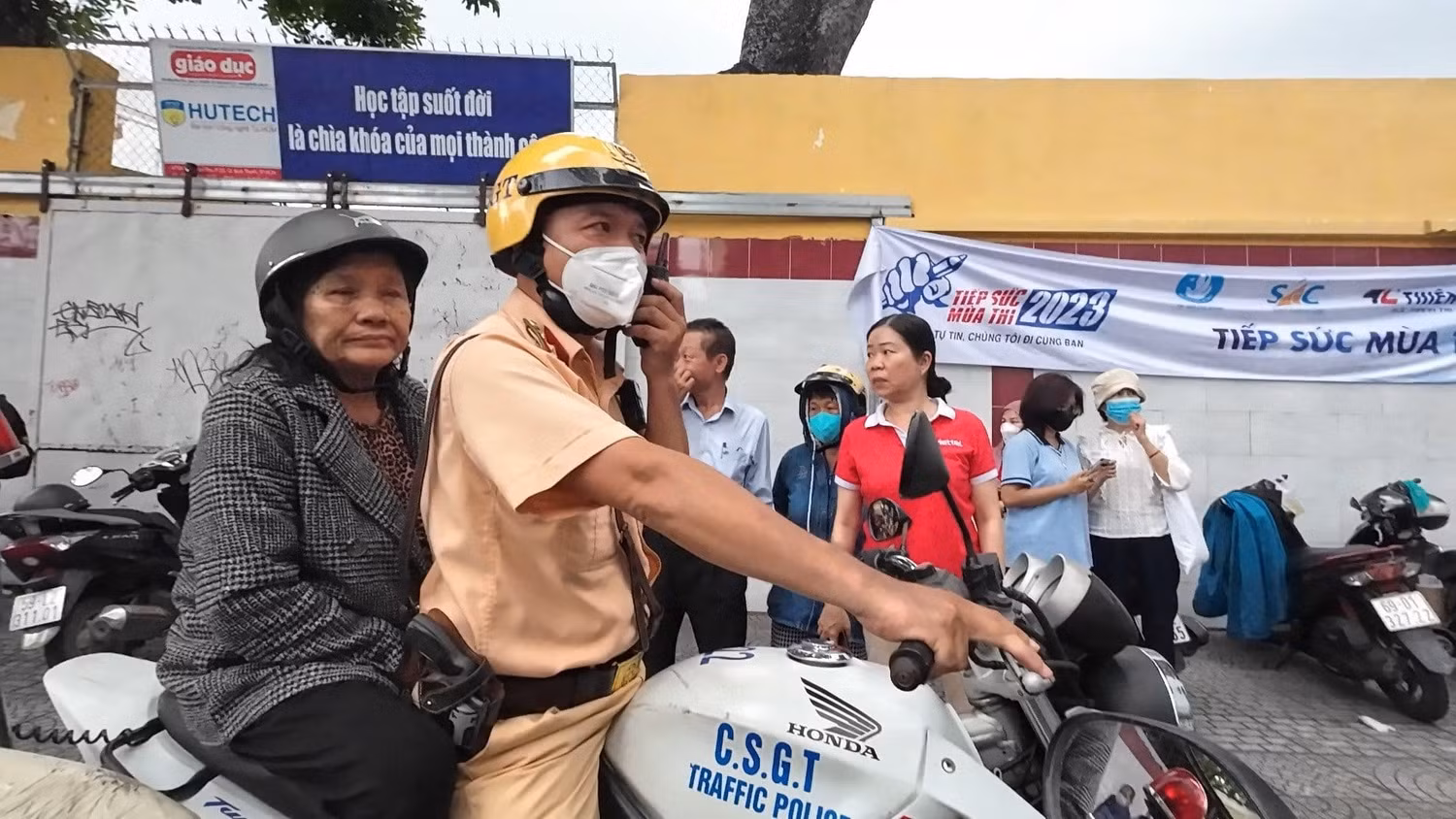 Chiến sĩ Cảnh sát giao thông hỗ trợ bà em T. về nhà lấy giấy tờ tùy thân cho em để dự thi (ảnh: PC08) Chiến sĩ Cảnh sát giao thông hỗ trợ bà em T. về nhà lấy giấy tờ tùy thân cho em để dự thi (ảnh: PC08)