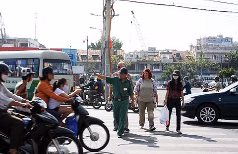 Anh Trần Duy Phong (Đội bảo vệ du khách nước ngoài) đang dẫn khách qua đường. Ảnh: Tá Lâm. Anh Trần Duy Phong (Dội bảo vệ du khách nước ngoài) đang dẫn khách qua đường. Ảnh: Tá Lâm.