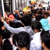 Hành khách khổ sở để chen được một chỗ lên xe buýt.