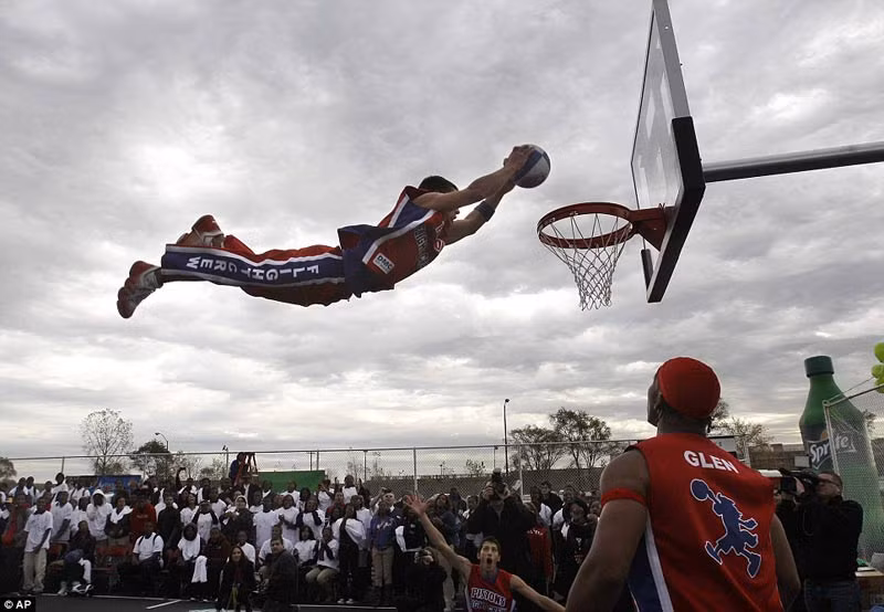 Một nam sinh trường trung học bay người thực hiện cú slam dunk trong trận đấu ở giải bóng rổ trung học Một nam sinh trường trung học bay người thực hiện cú slam dunk trong trận đấu ở giải bóng rổ trung học