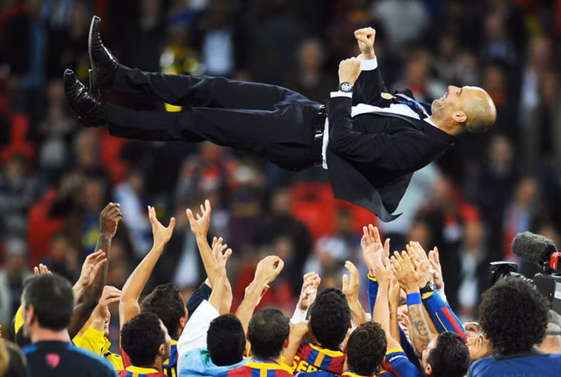 HLV Josep Guardiola của Barcelona được các học trò và BHL công kênh ăn mừng sau chiến thắng 3-1 của Barca trước Manchester United trong trận chung kết Champions League ngày 28/5/2011 tại sân Wembley, London, Anh.