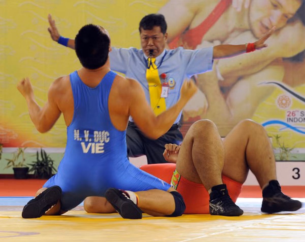 Nguyễn Văn Dực (trái) ăn mừng sau khi đánh bại Chivinn Chum (Cambodia), ở hạng cân 120kg môn vật tự do.