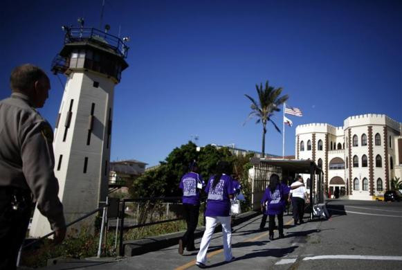 Các gia đình được bảo vệ hướng dẫn đi vào nhà tù San Quentin, California.