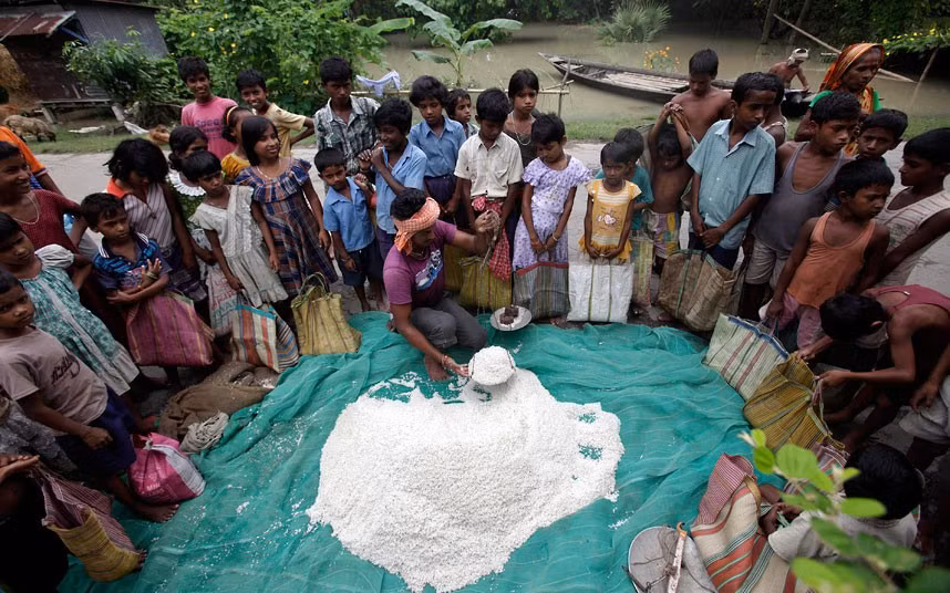 Những đứa trẻ đến nhận viện trợ gạo ở làng Burhabrhi ở Assam. Trận lũ lụt đã khiến cuộc sống vốn đã khó khăn của người dân vùng đông bắc Ấn Độ càng trở nên khó khăn hơn.