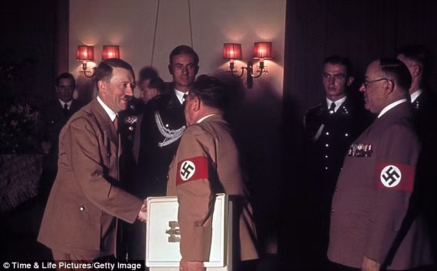 Hitler bắt tay với nhiếp ảnh gia của ông, Heinrich Hoffmann. Bác sĩ riêng của Hitler, Giáo sư Theodor Morell đứng ở bên phải trong tấm hình. Hitler bắt tay với nhiếp ảnh gia của ông, Heinrich Hoffmann. Bác sĩ riêng của Hitler, Giáo sư Theodor Morell đứng ở bên phải trong tấm hình.
