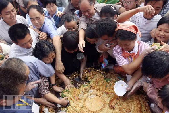 Người dân đổ xô kiếm cho mình một phần của chiếc bánh trung thu khổng lồ. Người dân đổ xô kiếm cho mình một phần của chiếc bánh trung thu khổng lồ.
