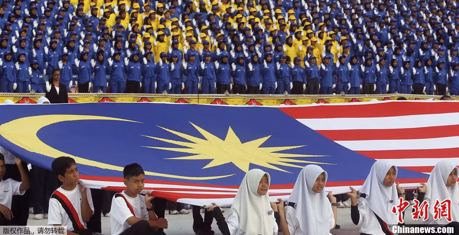 Những người có mặt tại Quảng trường đang hát quốc ca Malaysia.