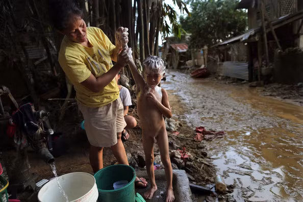 Người mẹ tắm cho cho cậu con trai nhỏ.