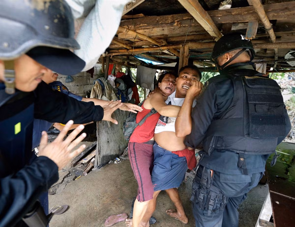 Cảnh sát quốc gia và thành viên đội đặc nhiệm Philippine đang cố gắng bắt giữ những người định cư trong quá trình cưỡng chế giải phóng mặt bằng một khu ổ chuột của họ tại thành phố Taguig, phía đông Manila, để mở đường cho các dự án phát triển mới.