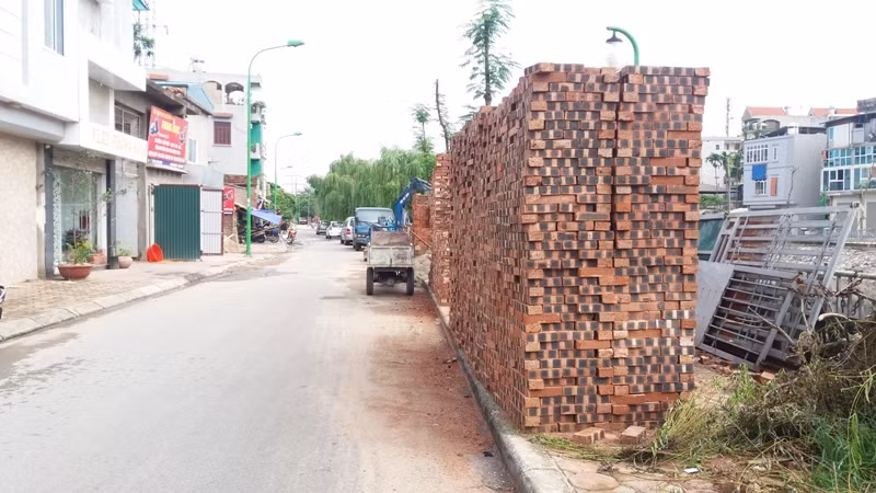 Bãi tập kết vật liệu của cửa hàng Phong Ngọc cũng chiếm chọn vỉa hè, người dân có muốn đi bộ qua đây cũng không được. Ảnh Trần Việt.