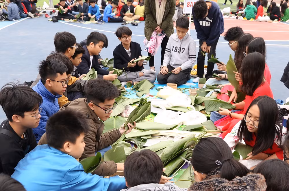 Trong lễ hội, các em học sinh được tham gia gói bánh chưng (Ảnh nhà trường cung cấp)