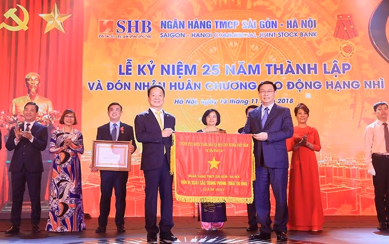 Ủy viên Bộ Chính trị, Phó Thủ tướng Chính phủ Vương Đình Huệ thay mặt Đảng và Nhà nước trao Huân chương Lao động Hạng Nhì và Cơ Thi đua của Chính phủ cho Ngân hàng SHB.