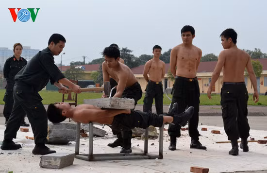 Chiến sĩ nằm thẳng trên 2 lưỡi của 2 thanh kiếm sắc, trên bụng đặt tảng bê tông Chiến sĩ nằm thẳng trên 2 lưỡi của 2 thanh kiếm sắc, trên bụng đặt tảng bê tông