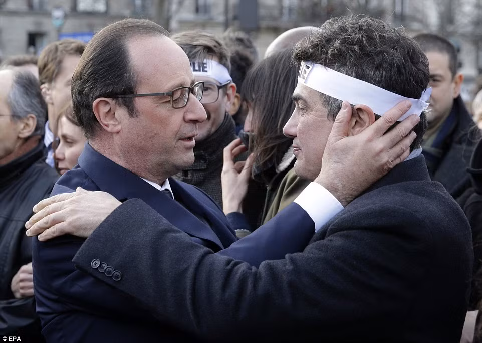 Tổng thống Pháp Francois Hollande (trái) an ủi Patrick Pelloux (phải) từ tạp chí châm biếm Charlie Hebdo.
